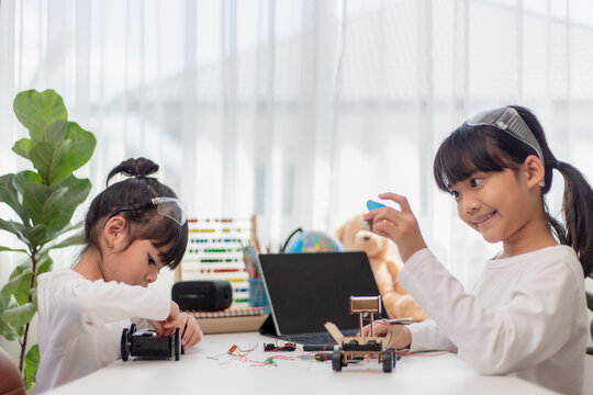 Asia Students Learn At Home In Coding Robot Cars And Electronic Board Cables In STEM, STEAM, Mathematics Engineering Science Technology Computer Code In Robotics For Kids Concept.