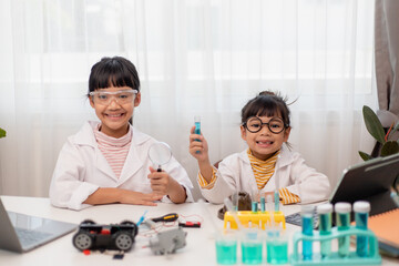 Asian little girl measuring the temperature of hot and cold water for easy science experimental online class