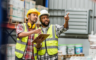 Two diverse professional male workers holding board, checking shipping stocks in storage, warehouse...