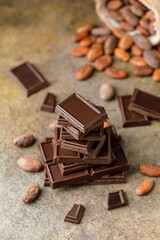 Broken chocolate pieces on dark background. Stack of dark chocolate. Chocolate concept