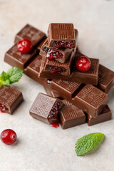 Chocolate bar with berry filling on white background. Stack of dark chocolate stuffed with berries. Chocolate concept