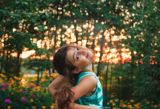 Portrait of Child playing on outdoor playground. Healthy summer activity for children in sunny weather. Cute girl smiling.