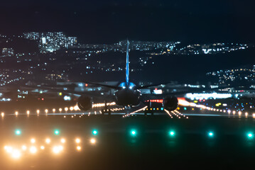 大阪伊丹空港に着陸する美しい飛行機と滑走路の夜景