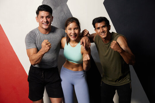 Portrait Group Of Young Friends Or Trainers Winner Gesture After Workout In The Gym