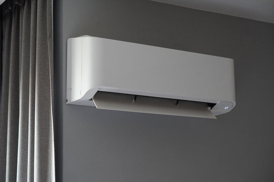 open plastic white wall mounted air conditioner on grey wall background, object, technology, decor, fashion, home, office, modern,copy space
