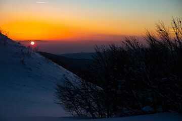 panorama of snow-capped mountains bieszczady at sunset, colorful winter sunset seen from the top of...