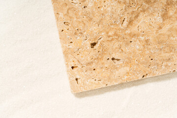 Travertine tile lying on a sand.