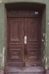 An old wooden brown-painted tenement door. 