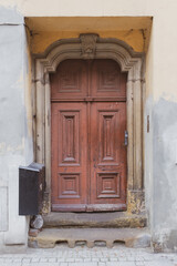 An old wooden brown-painted tenement door. 