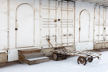 a trolley on wheels for cargo stands in a warehouse
