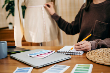 Fashion Designer Stylish Artist or creative designer drawing on sketch book with new project design.