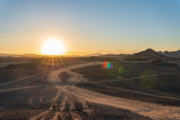 sunset over the mountains in the middle of the african desert - obrazy, fototapety, plakaty