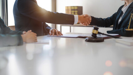 Lawyer consultant shaking hand with client sign contract agreement document. in law firm. Business...