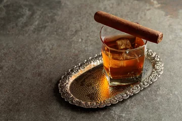 Fototapeten Whiskey with ice and cigar on an old stone table. © Igor Normann