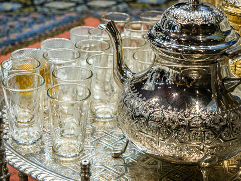 Traditional Moroccan decorated tea ceremony teapot and glasses on a tray at the Morocco stand in FITUR 2022
