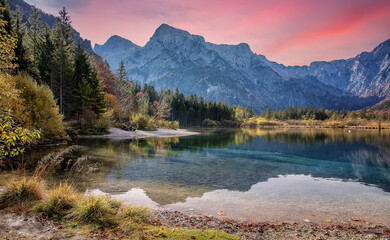 Impressive Autumn landscape during sunset. Almsee lake in front of the mount under sunlight. Amazing colorful sunset on the mountain lake. concept of an ideal resting place. Creative image. Austria