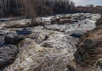 Water sports competitions on kayaks on a full-flowing river in spring