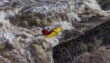 Obraz premium Water sports competitions on kayaks on a full-flowing river in spring