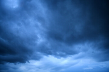 Storm clouds floating in a rainy day with natural light. Cloudscape scenery, overcast weather above blue sky. White and grey clouds scenic nature environment background