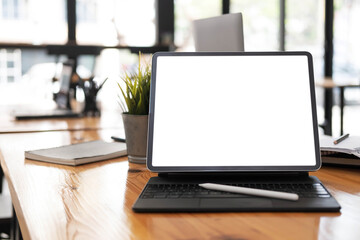 Fototapeta premium Photo of computer laptop with white blank screen putting on the modern working table with blurred comfortable office as background. Void screen for advertise concept.