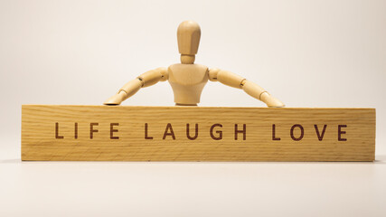 LIFE LAUGH LOVE written on the wooden surface. Wooden Concept