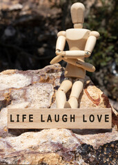 LIFE LAUGH LOVE written on the wooden surface. Wooden Concept