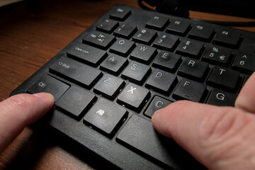A black keyboard of a computer and a person's hands pressing the CTRL and C keys to do the copy...