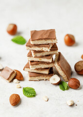 Chocolate pieces on white background with hazelnut. Stack of chocolate with hazelnut. Chocolate with walnut nougat