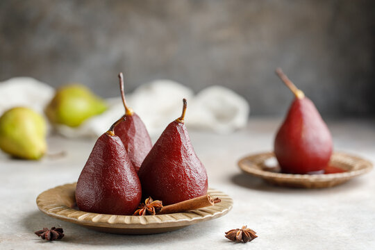 Pears in red wine on a plate with wine syrup and spices