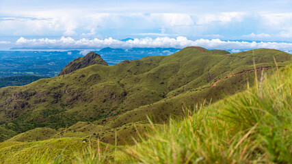 panorama of Costa Rica's cerro pelado mountains during a sunny day; mighty mountains covered with green, succulent grass; mountains in the tropics amidst rainforests