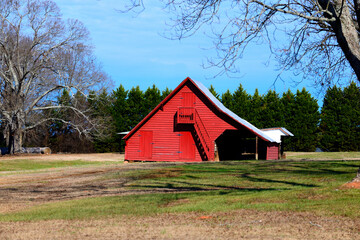 Obraz premium Rustic red barn shed at a farm located rural Georgia, USA. One of many throughout the countryside.