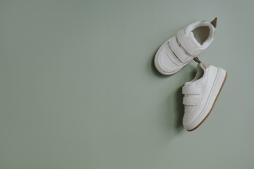 White mini sneaker shoes for baby, child. Flatlay, top view