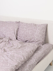 Lilac bed linen on the bed. Vertical. Family bed linen set