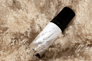 cosmetic bottle on pampas grass background Dry ear reeds or pampas grass decoration. Professional...