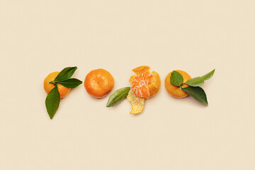 Ripe fresh orange yellow tangerines with green leaves, whole and peeled on beige background,...
