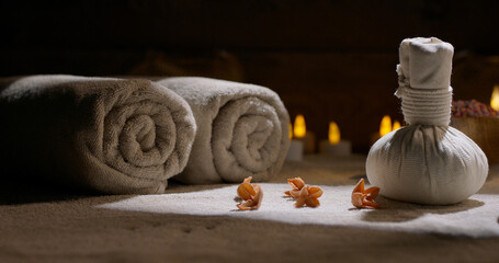 Spa salon equipment. Close up shot of two massage sacks filled with herbs. Towels and bath salt prepared for procedures 