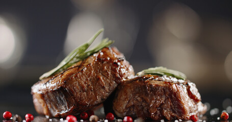 Beautiful peaces of grilled meat decorated on plate with rosemary and various spices. Art cookery being prepared before serving