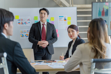 A group of young Asian businessmen Talking and planning work happily and have fun. at the company's office