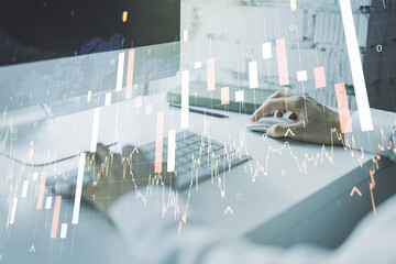 Abstract creative financial graph with world map and hands typing on laptop on background, financial and trading concept. Multiexposure