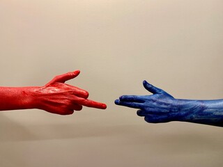 Dwie dłonie w kolorach czerwonym i niebieskim na jasnym tle. Język dłoni, układ palców,...