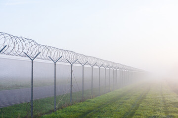 long fence border in mist