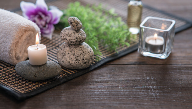 SPA decoration background image. Stones, candle , towel , plant and flower on a wood base