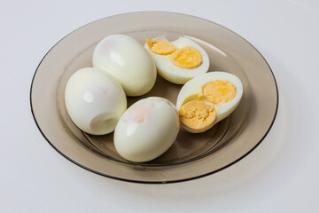 Whole and half chicken eggs on a plate. An egg has two yolks.