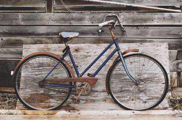 Fototapeta na wymiar Old bicycle leaning on rustic wood and boards