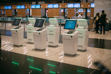 Electronic check-in counters in the departure area with LCD screens of self-service computer kiosks...