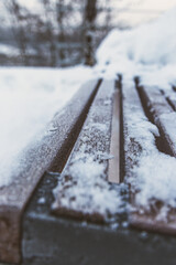 The seat of a bench covered with snow
