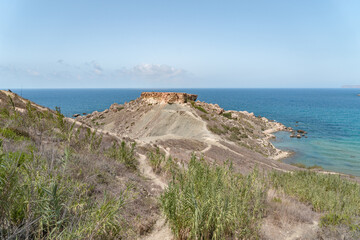 Fototapeta na wymiar Clay cliffs and little peninsula in Malta near Ghajn Tuffieha and Qarraba Bay. 