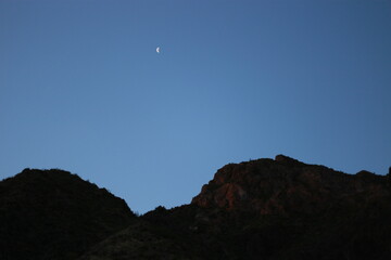 Cielo nocturno atardecer con luna cuarto menguante y montañas, Jujuy , Argentina. Sunset sky with the waning quarter moon and mountains.