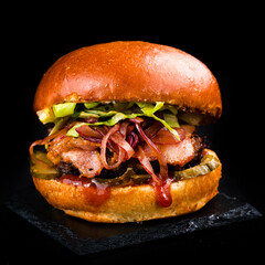 Fresh beef burger with cheddar cheese, pickles, tomatoes, lettuce, red onion, bacon and barbecue sauce.