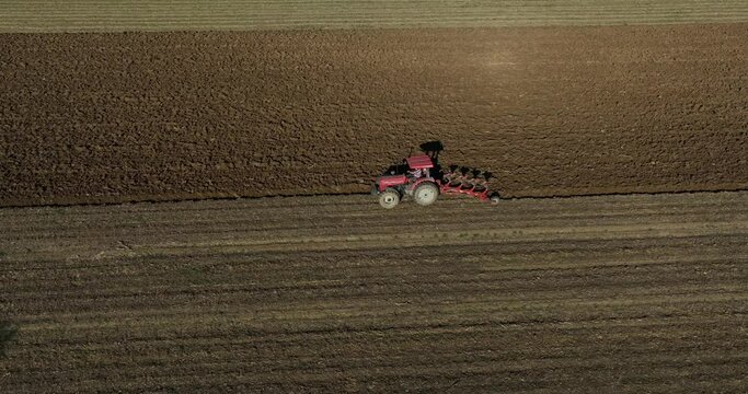 Farm field, farmers work with tractor on farmland,